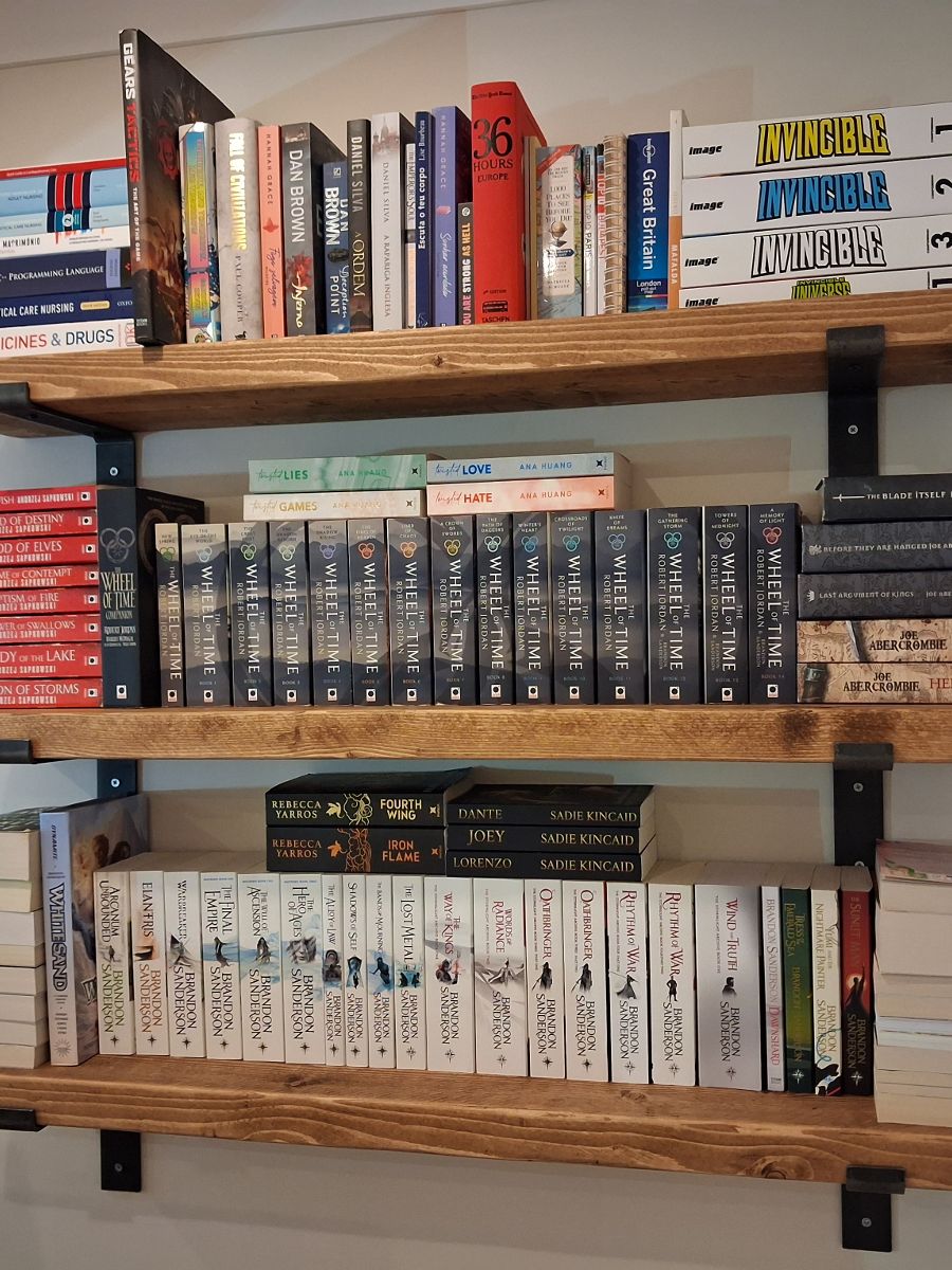 Three timber shelves fitted to a plasterboard wall and loaded with books